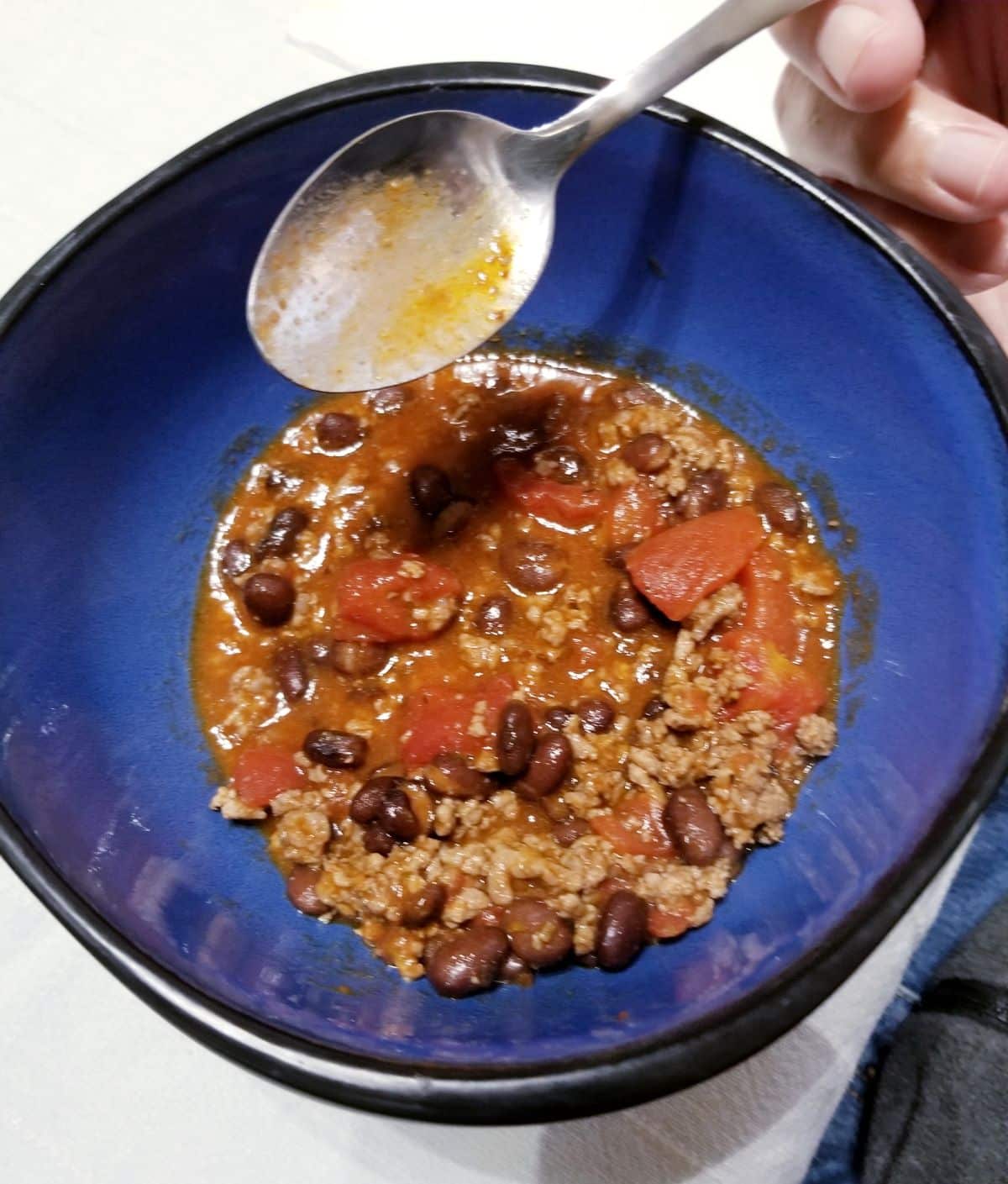 A bowl of easy chili and a spoon.