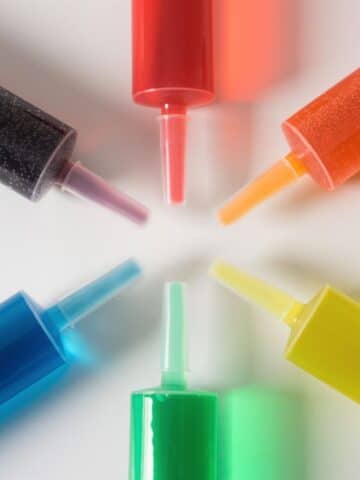 Several jello shots in syringes in different colors.