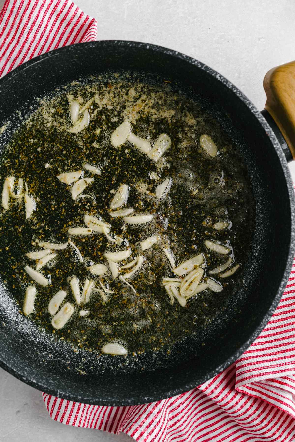 Garlic being fried in a pan of butter.