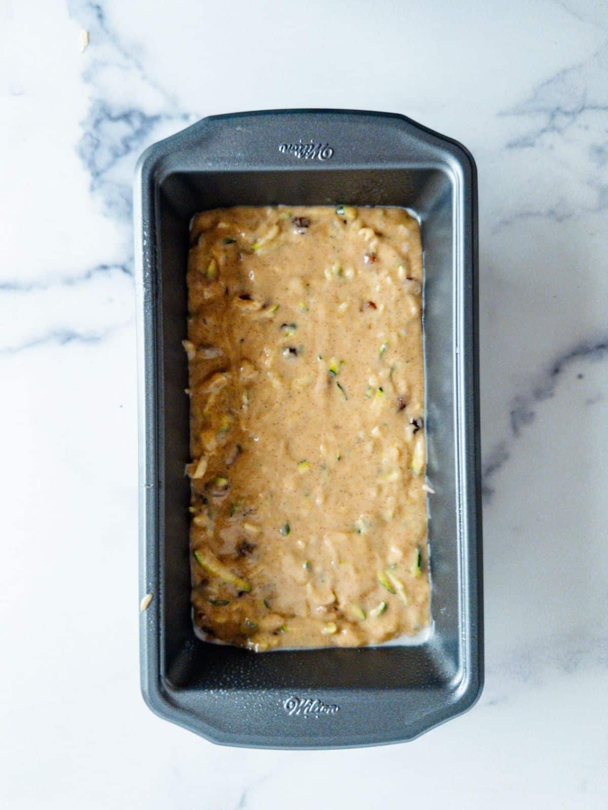 Zucchini bread batter in a loaf pan.