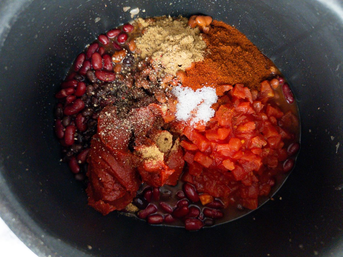 Salt and spices on top of stovetop chili.