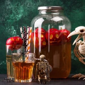 An apple harvest cocktail punch with halloween decorations.