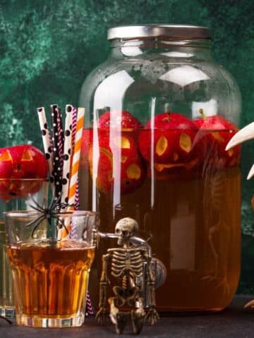 An apple harvest cocktail punch with halloween decorations.