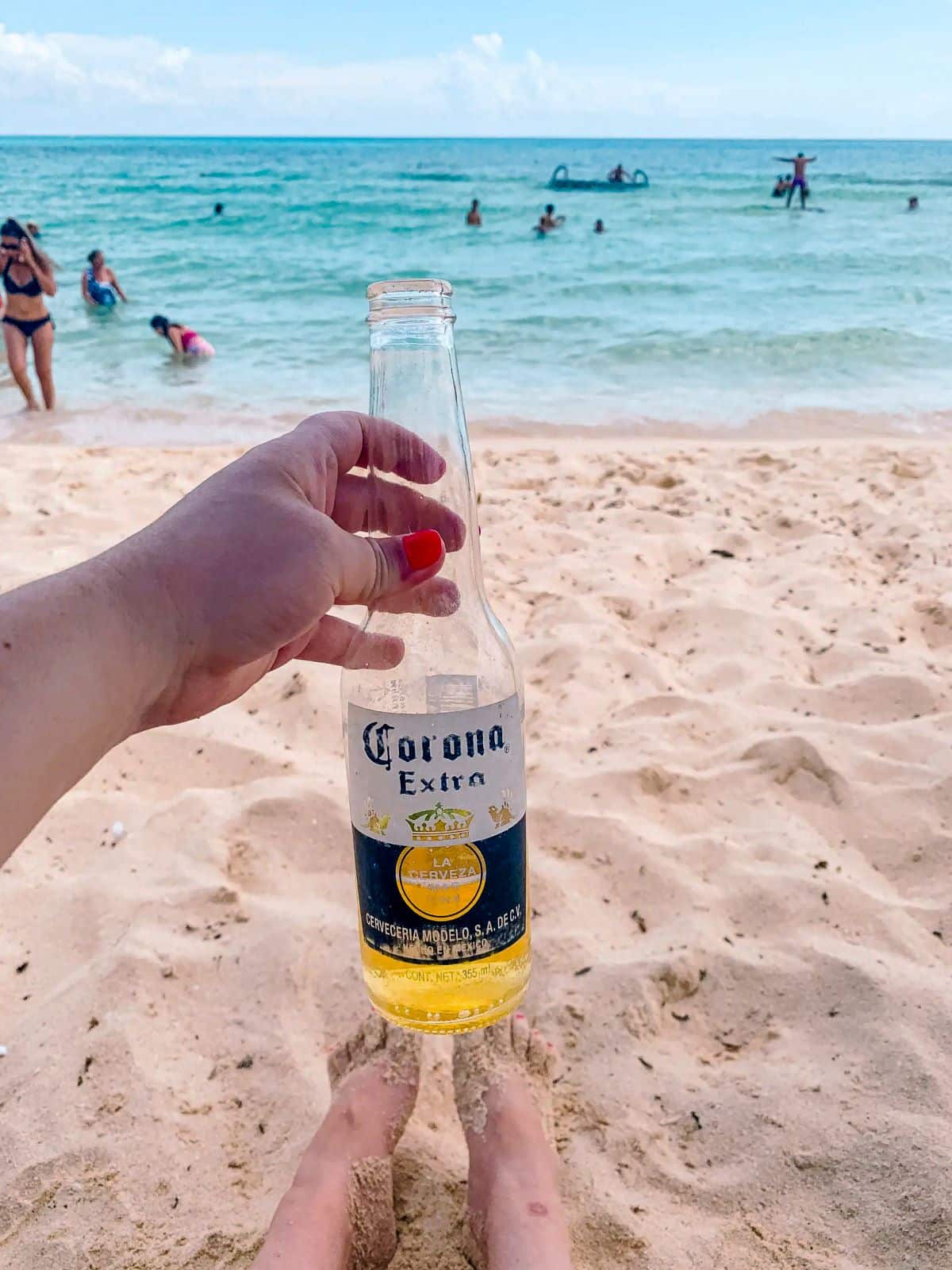 The blog author holding a Corona beer on the beach in Mexico.