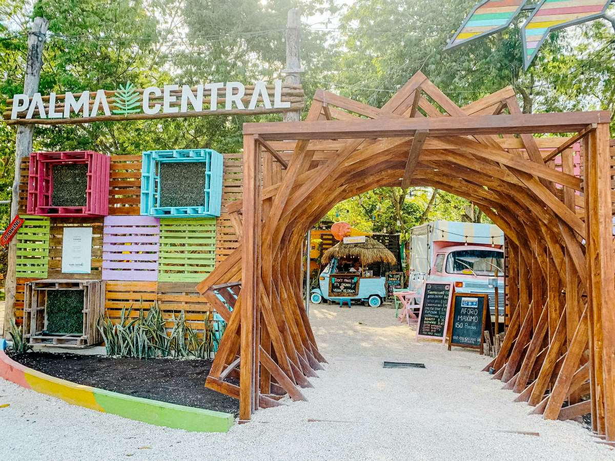 A Palma Central sign and food trucks in Tulum.