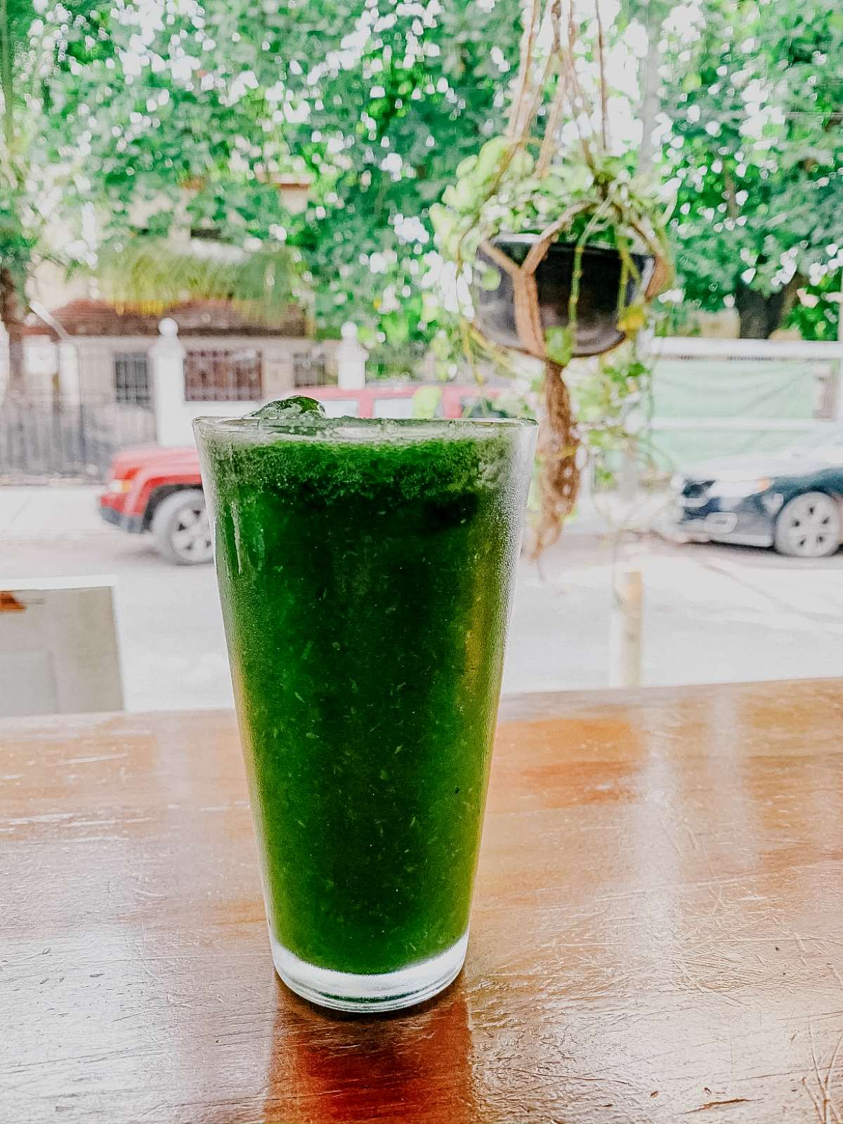A green smoothie on a table outside in Tulum.